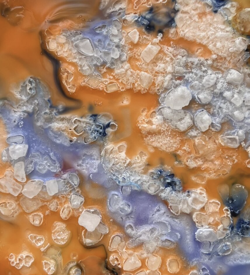 Image of orange salt crystals that form into an artistic looking layer.